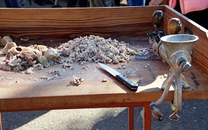 Reste vom Schlachten und Zerlegen eines Schweins liegen auf einem Holztisch neben einem Fleischwolf