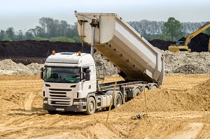 dump truck with lifted hollow while unloading on a construction site