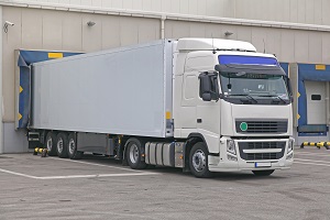 white walking floor trailer stands for loading in front of a warehouse