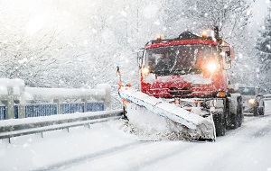 red snowplough in operation during snowfall