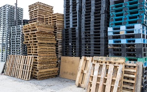 a few high stacks of wooden and plastic pallets of different colours