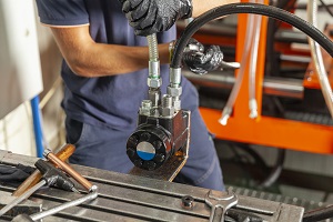 hydraulic lines at a workbench with a worker in the background