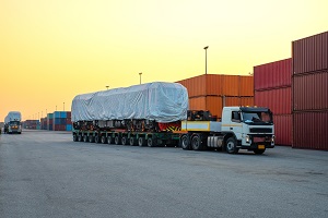 low-loader with a locomotive as cargo, pulled by a truck