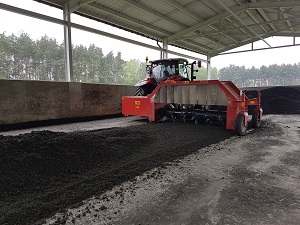 Maschine verteilt Kompost in einer Kompostierungsanlage