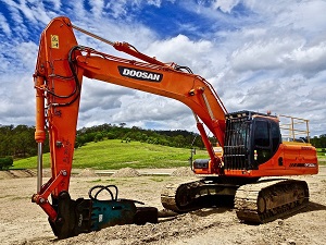 orange coloured demolition excavator on a sand place